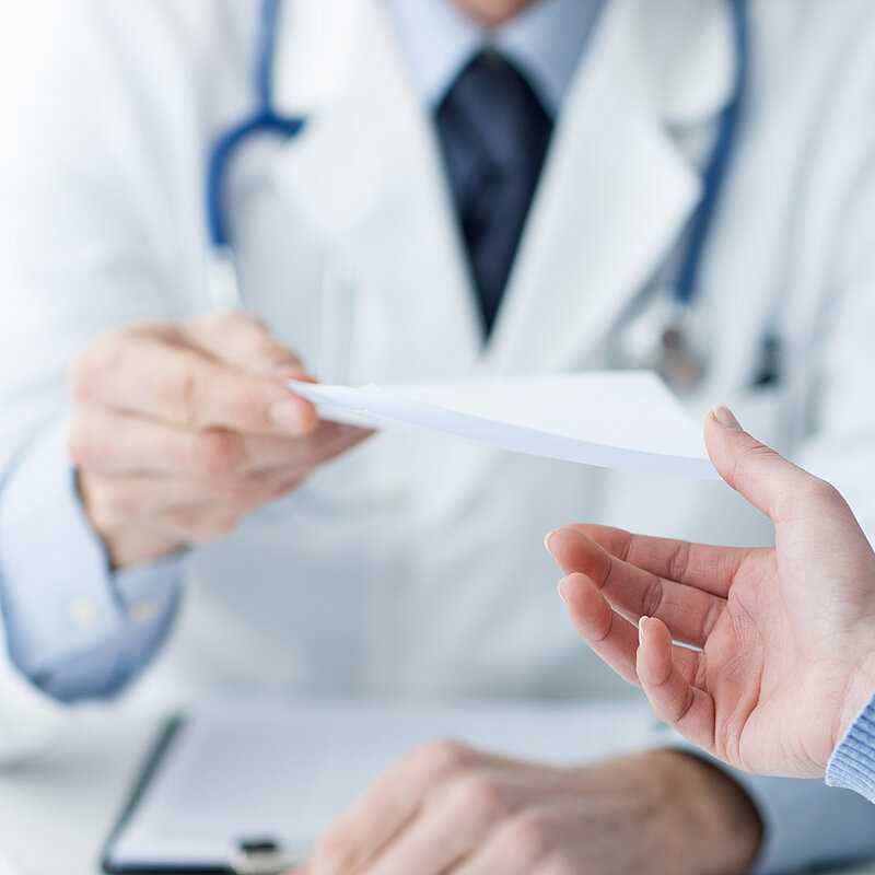Arzt gibt Patientin ein Rezept