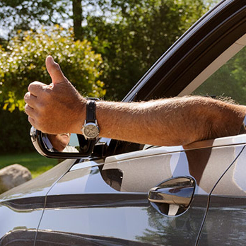 Mann zeigt Daumen hoch aus dem Fahrerfenster